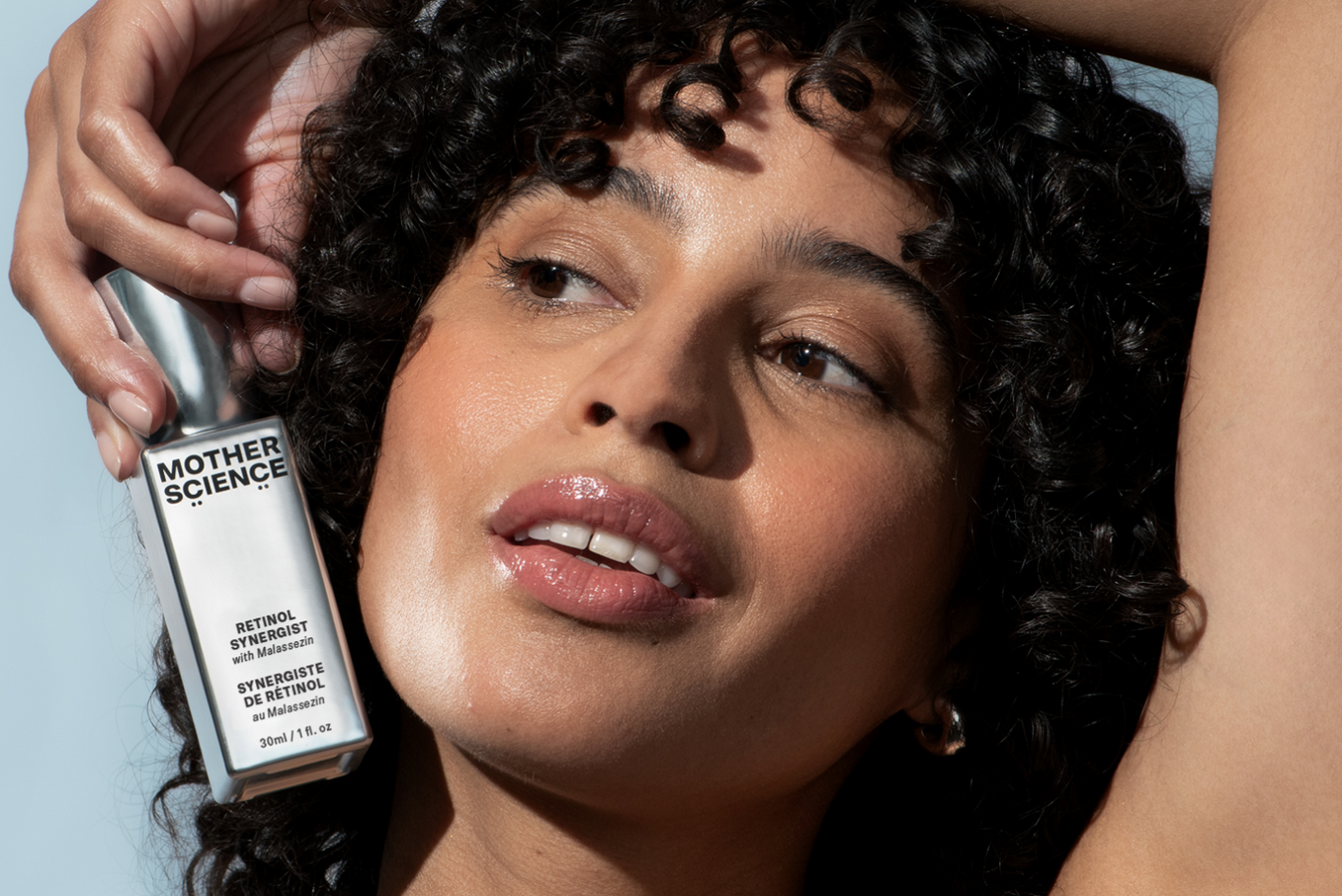 Woman holds bottle of Mother Science Retinol Synergist Encapsulated retinol