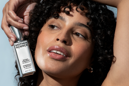 Woman holds bottle of Mother Science Retinol Synergist Encapsulated retinol